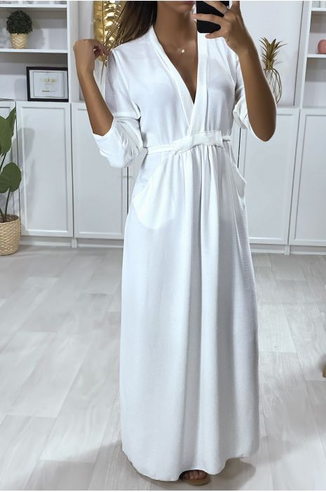 Longue robe blanche ample en vol V avec ceinture et poches.